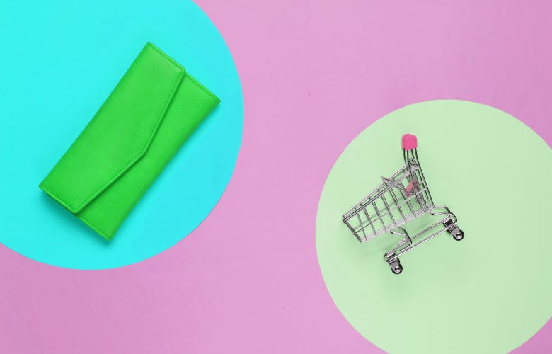 wallet and miniagreen wallet on blue circle and miniature shopping basket on green circle on pink backgroundture shopping basket on pink background